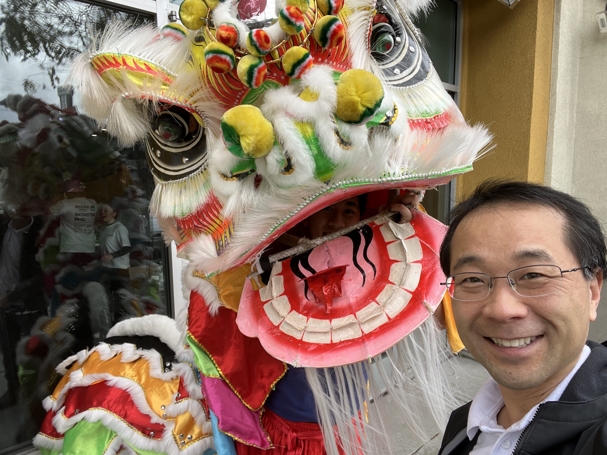 Man standing with with costumed lion dancer